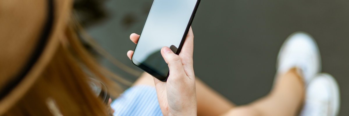 Person mit Smartphone in der rechten Hand