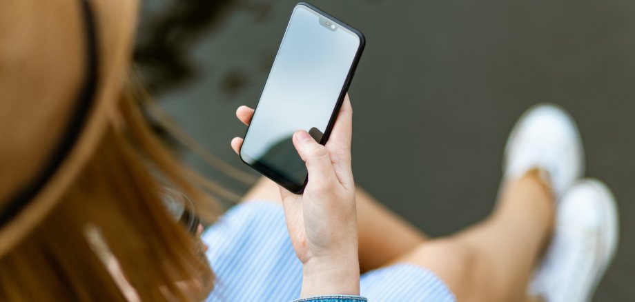 Person mit Smartphone in der rechten Hand
