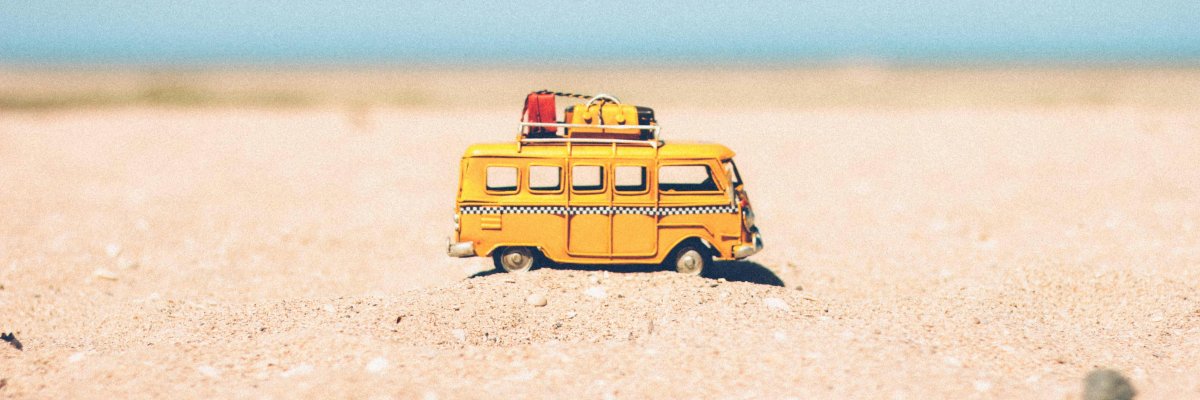 Ein Spielzeugbus steht im Sand
