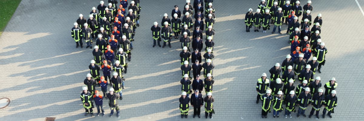 Feuerwehrleute formen die Zahl 112