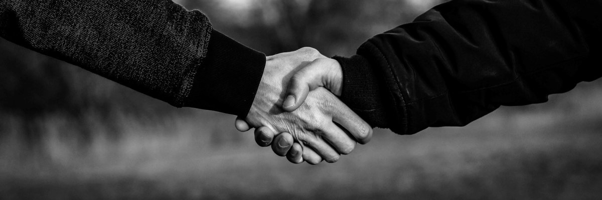 Zwei Menschen geben sich die Hand
