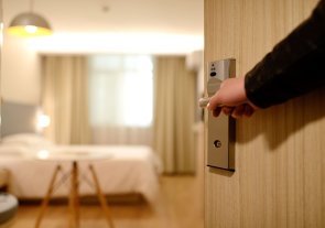 Jemand öffnet eine Tür in ein Hotelzimmer Jemand öffnet eine Tür in ein Hotelzimmer