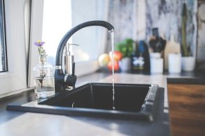 Ein laufender Wasserhahn in einer Küche Ein laufender Wasserhahn in einer Küche